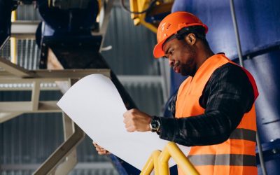 travailleur-afro-americain-debout-uniforme-portant-casque-securite-dans-usine_1303-30612